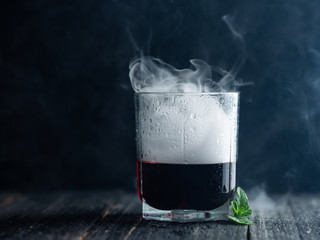 Smoke in a glass with red alcohol