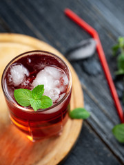 Red alcoholic cocktail with ice and mint in a glass