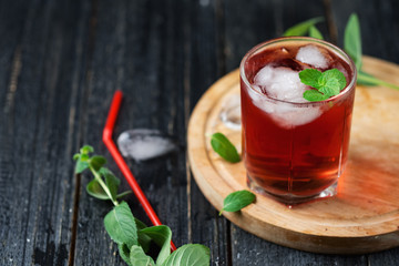 Red alcoholic cocktail with ice and mint in a glass