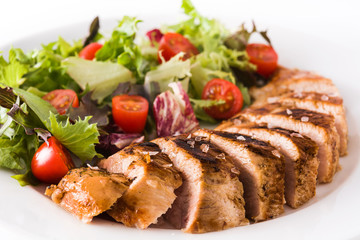 Grilled chicken breast with vegetables on a plate isolated on white background. Close up