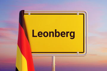 Leonberg. Gelbes Schild/Ortsschild. Flagge von Deutschland hängt darüber. Himmel mit Sonnenuntergang oder Sonnenaufgang