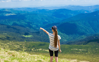 Fototapeta premium woman hiking pointing to the sky enjoy the beautiful view at mountain for sun light