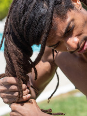 Close-up of a black man who slips his dreadlocks when he comes out of the pool