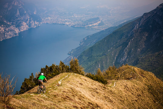 LAKE GARDA, ITALY - A mountain biker riding a narrow precipitous trail high above Lake Garda.