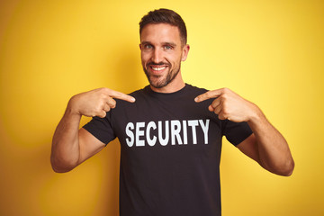 Young safeguard man wearing security uniform over yellow isolated background looking confident with...