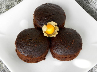 chocolate cupcakes on a white plate and physalis