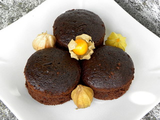 chocolate cupcakes on a white plate and physalis