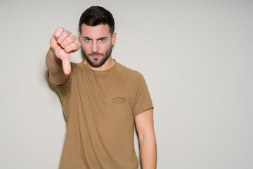 Young handsome man over isolated background with angry face, negative sign showing dislike with...