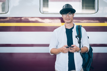 Asian man is traveler, he is waiting for their train. Outdoor adventure travel by train concept. Bangkok, Thailand. Happy/positive/healthy hike/travel/wanderlust concept © jumlongch