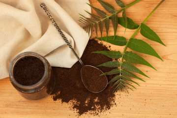 A glass jar of ground coffee, body scrub, mixed sugar, oil, essentials.Homemade cosmetic for peeling,spa care,copy space