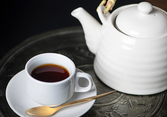 Coffee cup and ceramic coffee pot on metal tray. Breakfast.