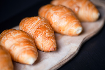 Close-up of various croissants on confectioner's wooden board. Sweet for breakfast.
