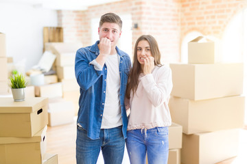 Fototapeta na wymiar Beautiful young couple moving to a new house looking stressed and nervous with hands on mouth biting nails. Anxiety problem.