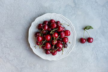 White plate full of cherry berries