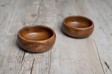 Close-up of two brown wooden bowls on gray wooden table. Traditional rustic bowl.