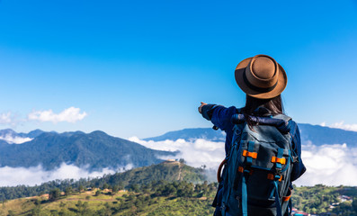 Fototapeta na wymiar asian women backpacker freedom travel trip pointing holding hand looking mountain fog landscape view