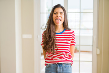 Young beautiful woman wearing casual t-shirt sticking tongue out happy with funny expression. Emotion concept.