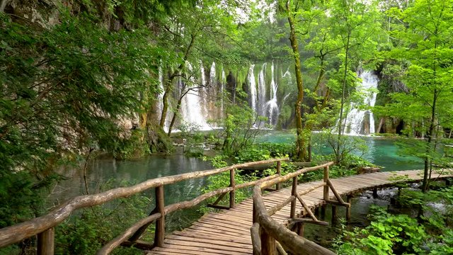 Plitvice Lakes National Park, Croatia, Europe. Walking on boardwalk in Plitvice lakes with turquoise water, waterfalls and green trees. Gimbal shot, 4K