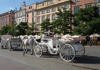 Naklejka premium traditional cabs for tourists in Krakow's Market Square