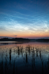 Fototapeta na wymiar Night shining clouds over lake