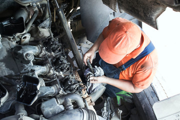 Mechanic repairs a truck. adjustment of valves of the diesel motor. Replacement nozzles. - obrazy, fototapety, plakaty