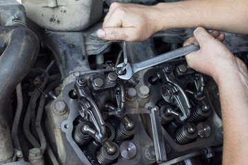 Mechanic repairs a truck.  adjustment of valves of the diesel motor.  Replacement nozzles.