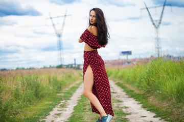 Young beautiful woman in dress in the summer park