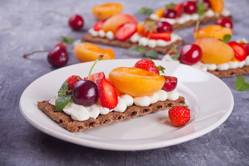 Crisp bread with creme cheese, fruit and berries
