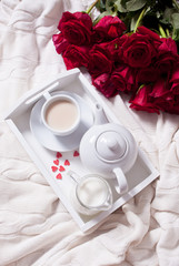Close up of cup of tea with red rose on the white tray