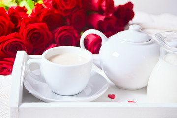 Obraz na płótnie Canvas Close up of cup of tea with red rose on the white tray