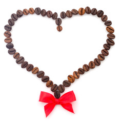 Coffee beans in the shape of a heart with a bow.