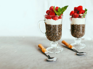 dessert made from healthy foods Chia, coconut and raspberry dessert in a beautiful glass on a light...