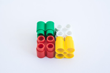 Colorful plastic bricks and details of toys on a white background. Top view