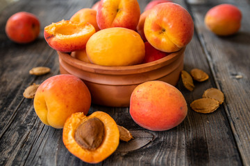Fresh organic apricots in a clay bowl on old wooden table