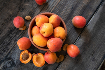 Fresh organic apricots in a clay bowl on old wooden table