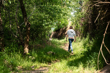 Obraz premium Woman walking on a forest trail.