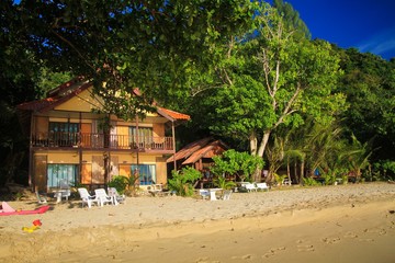 Ko Chang, Thailand: View on white sand beach with green trees and colorful wood houses resort