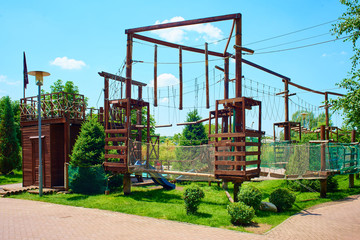 Fototapeta na wymiar Wooden playground for children. Fun games with obstacles, amusement, quests, extreme park for kids
