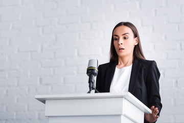 scared lecturer suffering from fear of public speaking while standing on podium tribune