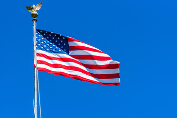 American flag at the Golden Gate National Cemetery, San Bruno, California, USA. Isolated on blue background.