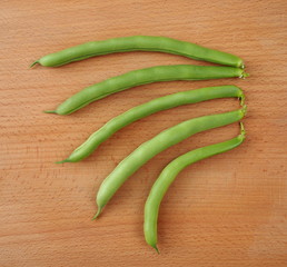 Young pods of asparagus haricot on a wooden surface