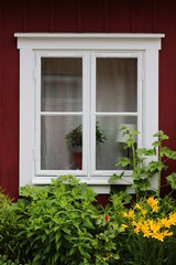 Fototapeta na wymiar Window in an old Swedish house. Vintage window in the red house