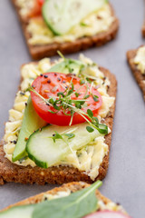 Sandwiches with cream cheese, vegetables and salami.