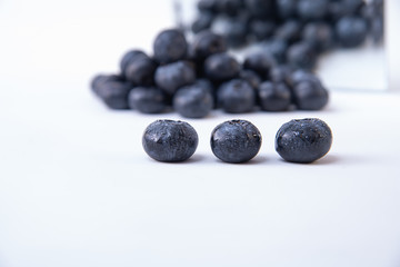 Picture of ripe blueberries - Pile of ripe blueberries in the background - Tasty and ripe wet blueberries on a white table