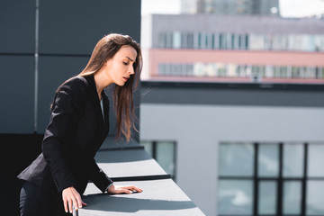 young businesswoman, suffering from acrophobia, looking down rooftop - obrazy, fototapety, plakaty