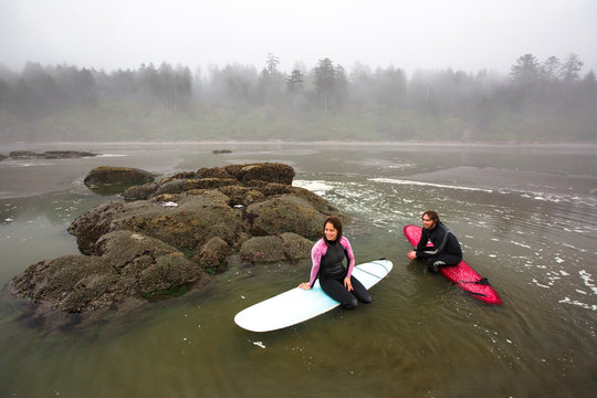 A male and female surfer wait for waves while floating in a tidepool on the beach near Kalaloch campground in the Olympic National Park in Washington State.