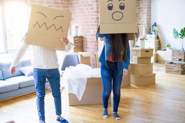 Fototapeta na wymiar Crazy couple wearing boxes with funny faces over head, having fun happy for moving to a new house