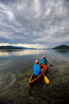 Rear view of man and woman rowing a canoe in Priest Lake