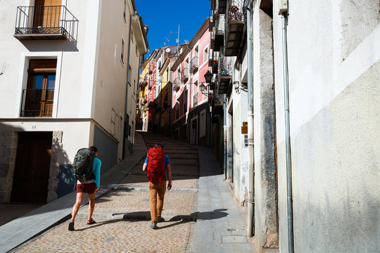 A man and a woman trek through the medieval streets of the old town section of Cuenca, Spain, a UNESCO World Heritage Site..