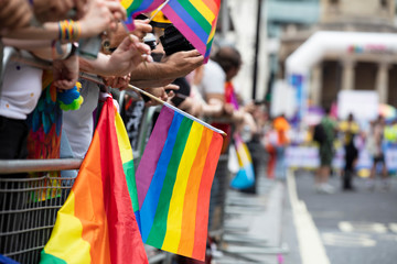 Spectators waves a gay rainbow flag at an LGBT gay pride community event